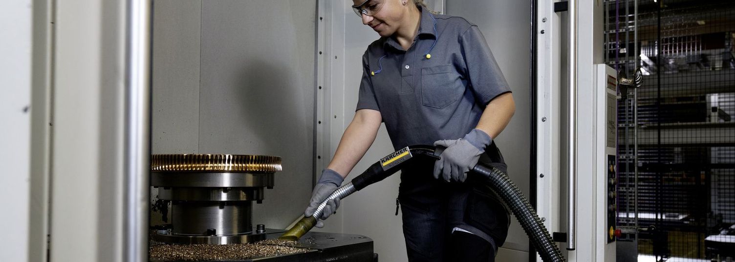 A person sucks swarf from a machine 