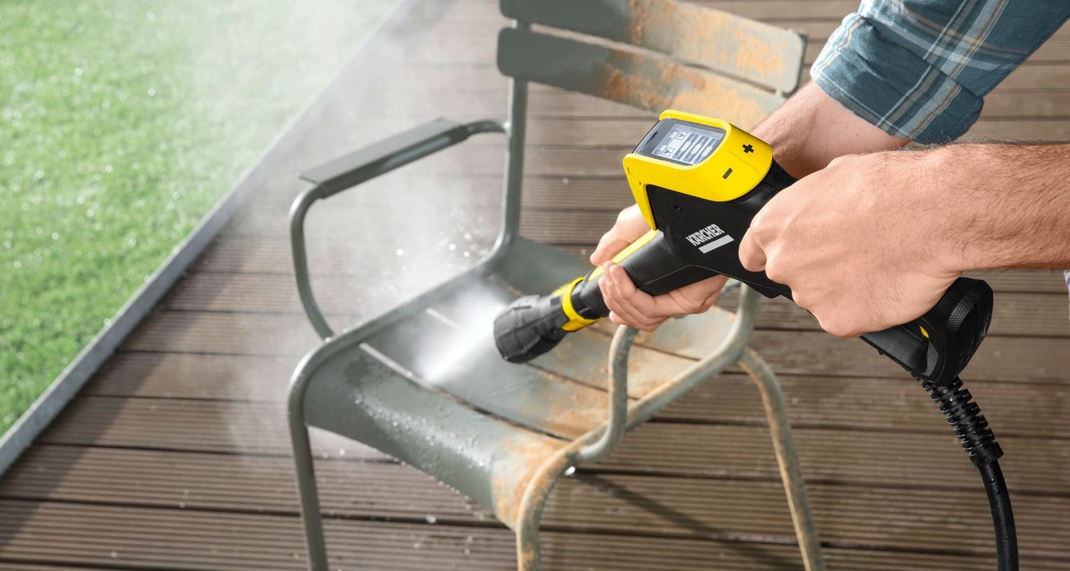 A metal garden chair is cleaned with a Kärcher wash brush and foam