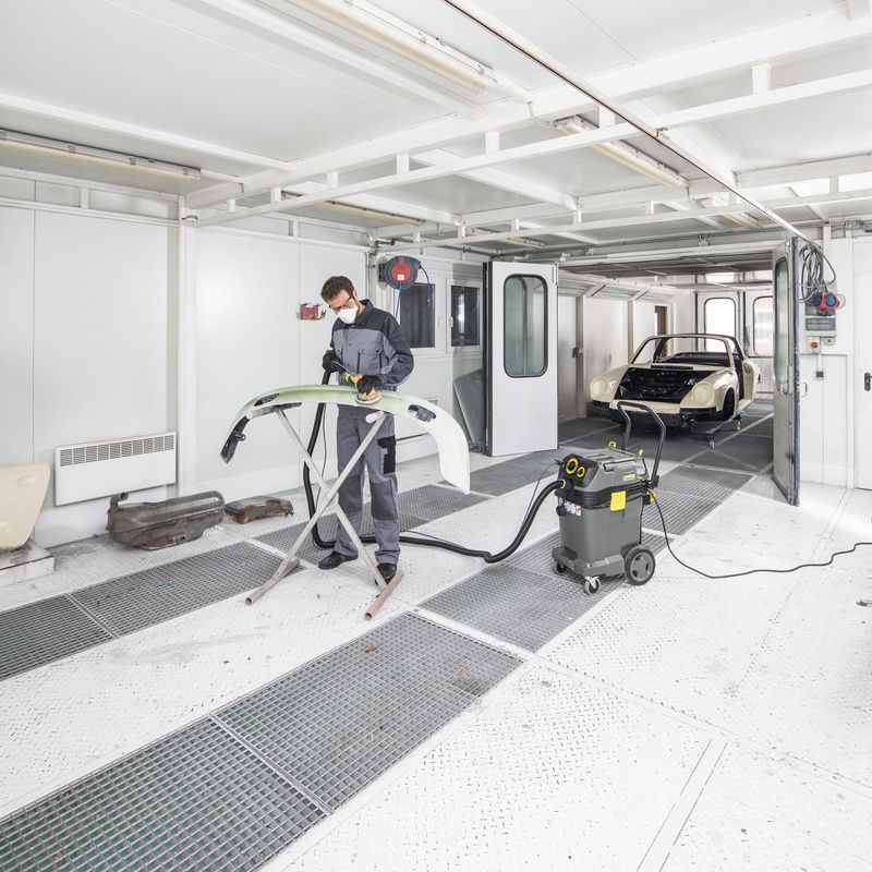 Person uses Kärcher safety vacuum cleaner in paint shop