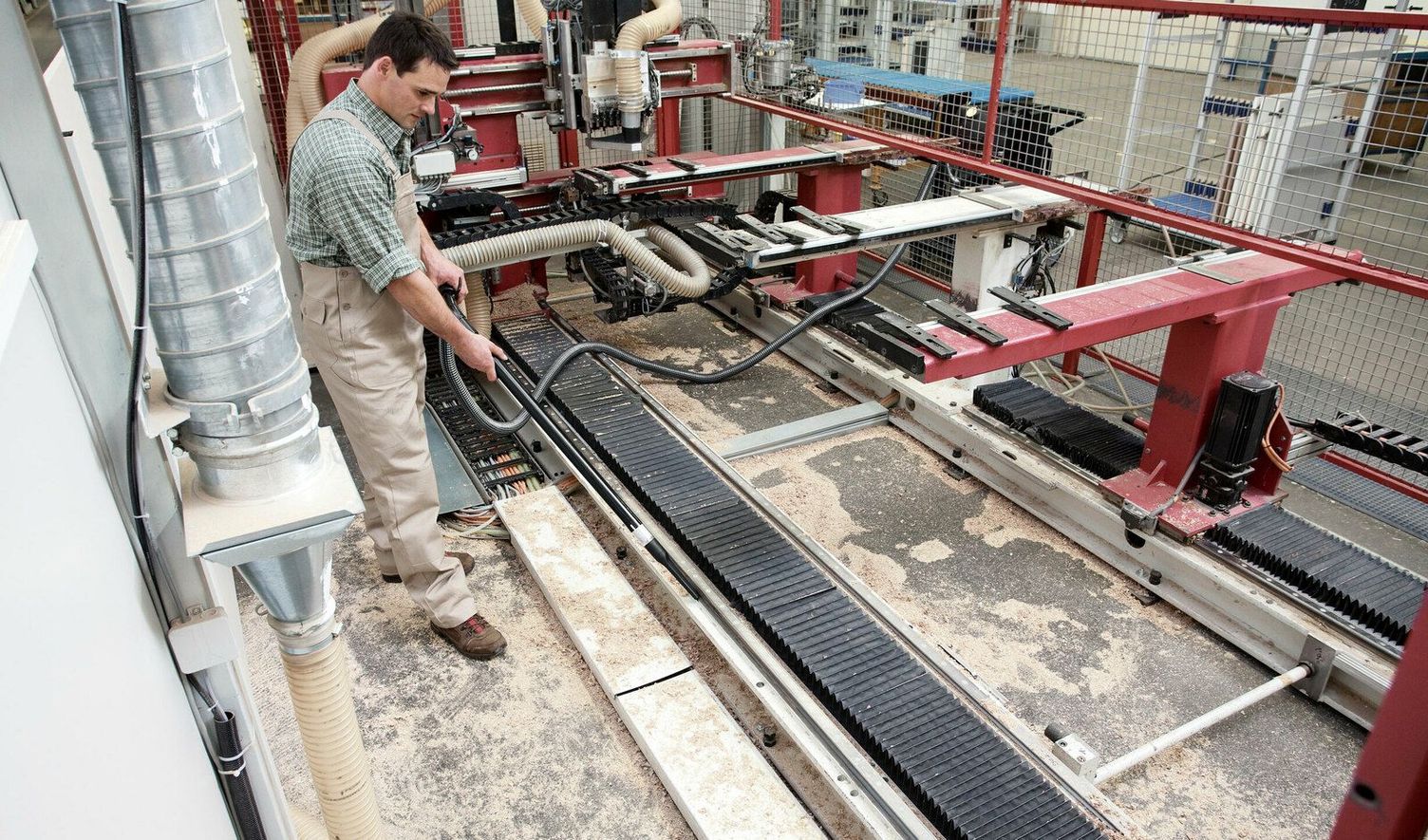 A person vacuums the surface of a saw bench