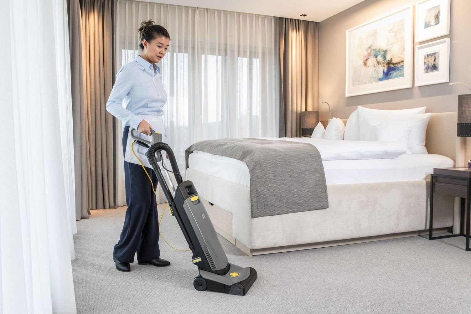 Cleaning hotel room with carpet vacuum sweeper