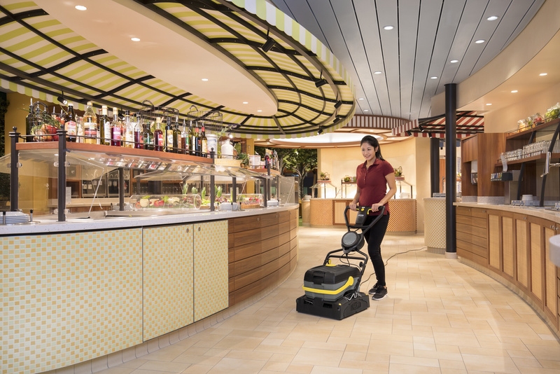 A person cleaning the floor with a scrubber dryer