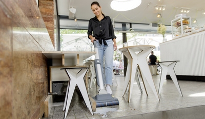 A person cleaning the restaurant floor with a microfiber mop system