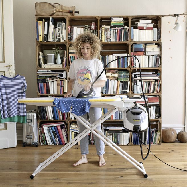 Woman ironing using a Kärcher steam cleaner SC 5 EasyFix with steam pressure iron