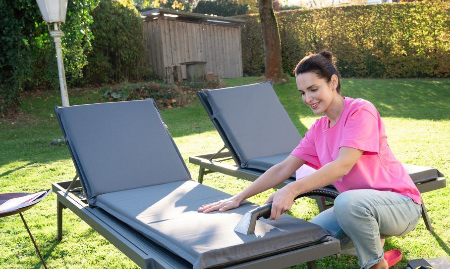 A woman cleans the fabric covers of her garden loungers