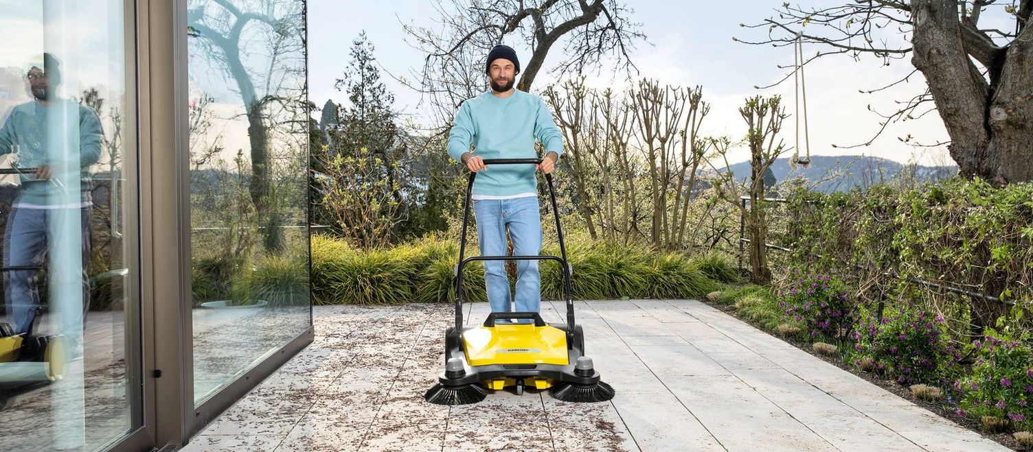 Clean patio slabs with sweeper A man cleans a patio with a Kärcher sweeper