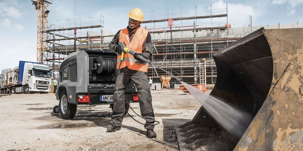 One person cleans a dredger using a Kärcher HDS Trailer 