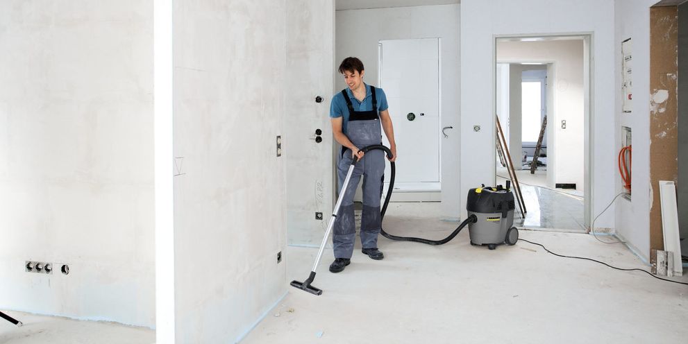 One person cleans an unfinished floor using a Kärcher Wet and Dry Vacuum 