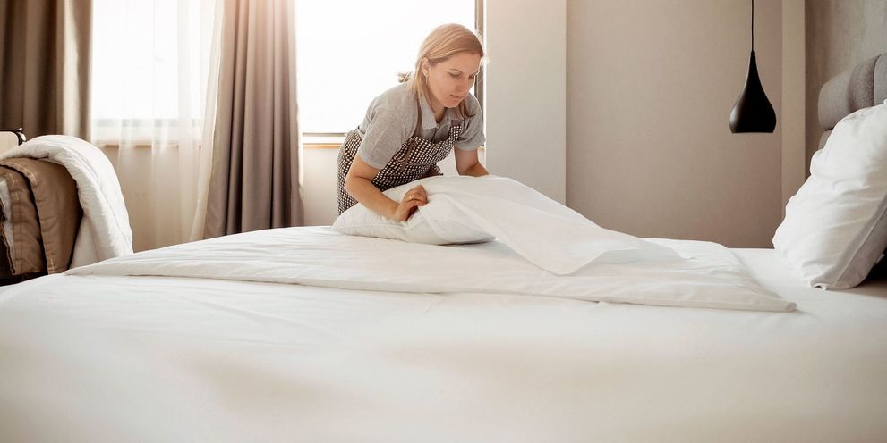 A woman makes the hotel bed
