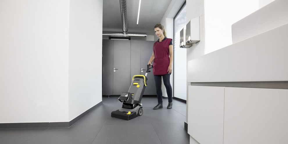 One person cleans the floor of a locker room
