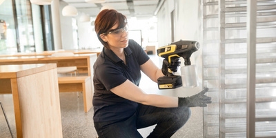 Person disinfecting tray trolley with Kärcher steam spray attachment