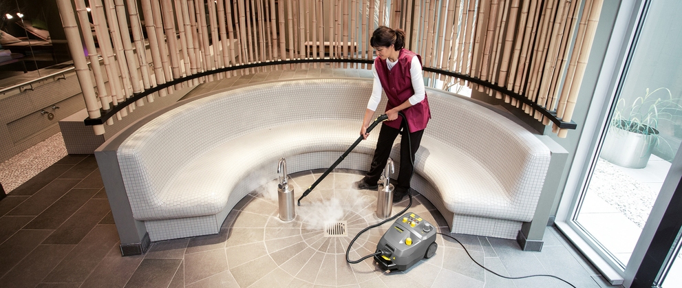Person cleaning hotel foyer with steam cleaner
