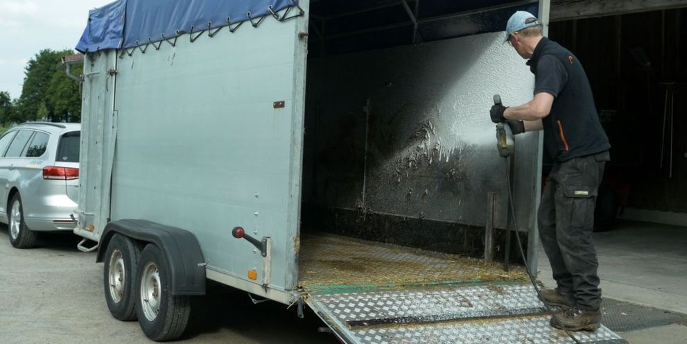Cleaning livestock trailer interior with cleansing foam