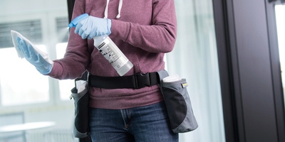 Person spraying a disinfectant on a cloth
