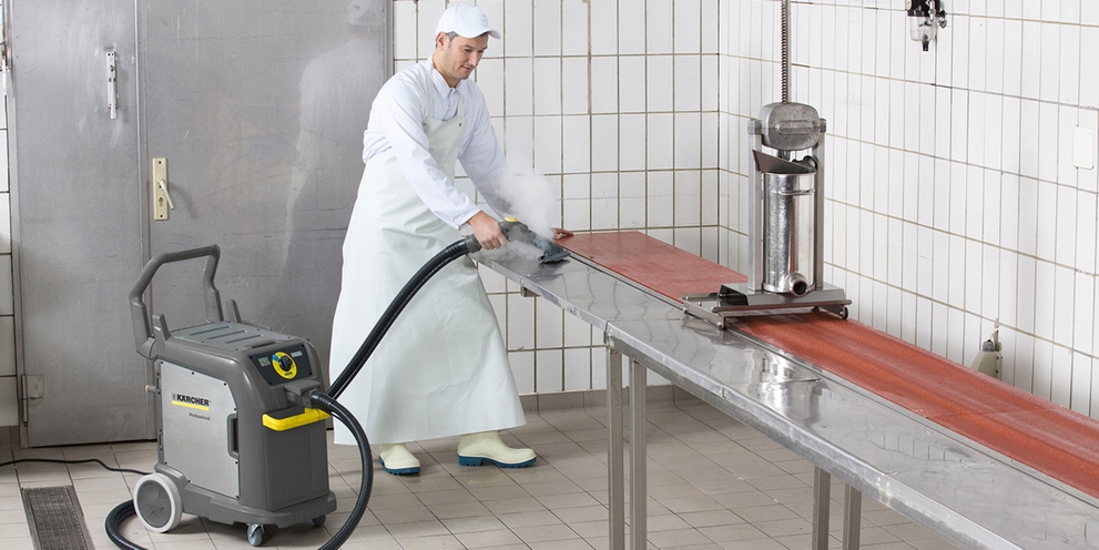 A person cleaning a work station in a butcher shop