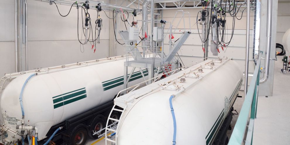 View of a large white hall containing two tank silos.