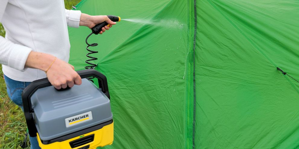 A green tent being cleaned with a Kärcher OC 3