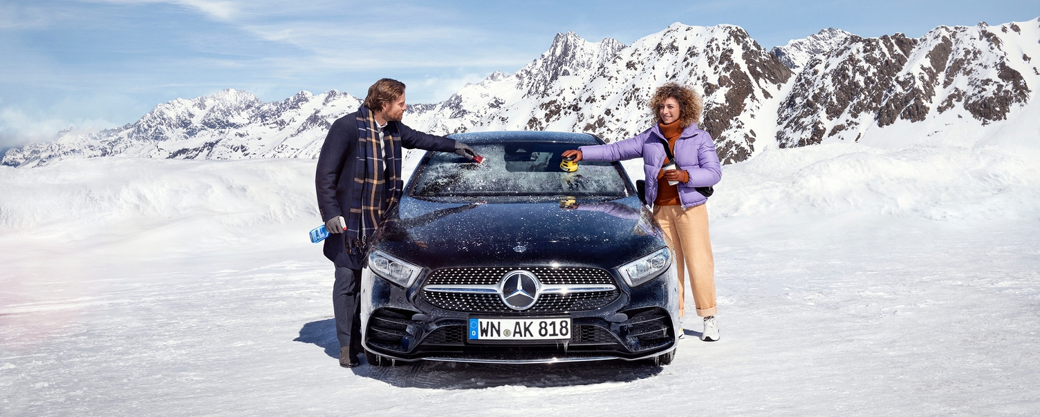 Couple removing ice from their car with the Kärcher electric ice scraper Couple removing ice from their car with the Kärcher electric ice scraper