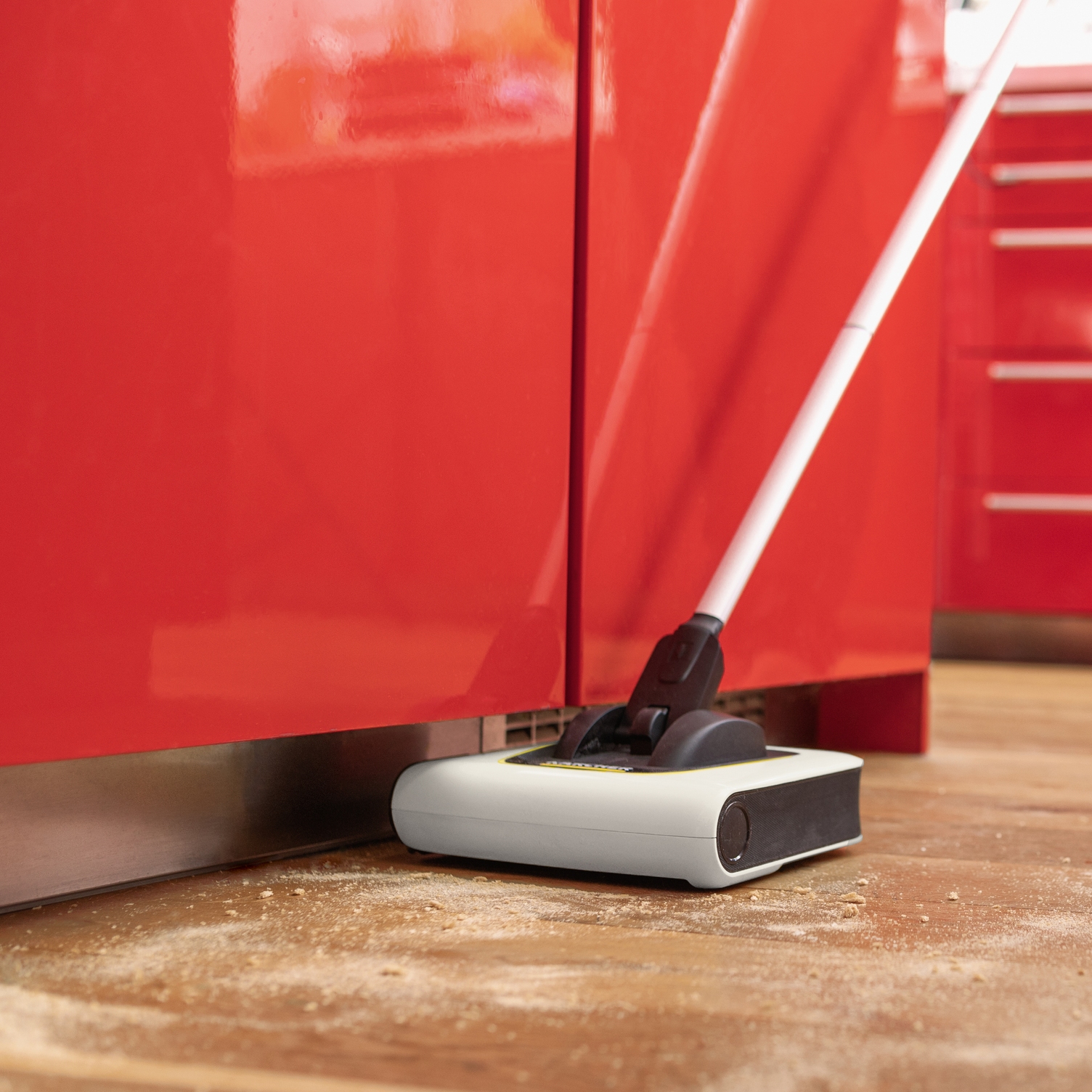 Cordless electric broom cleaning under a sideboard