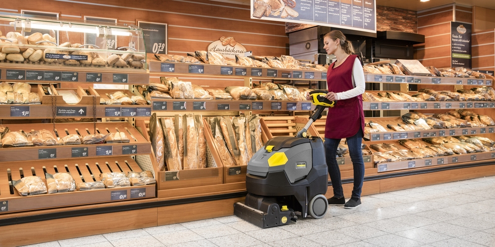 Woman cleans bakery with Kärcher machine Woman cleans bakery with Kärcher machine