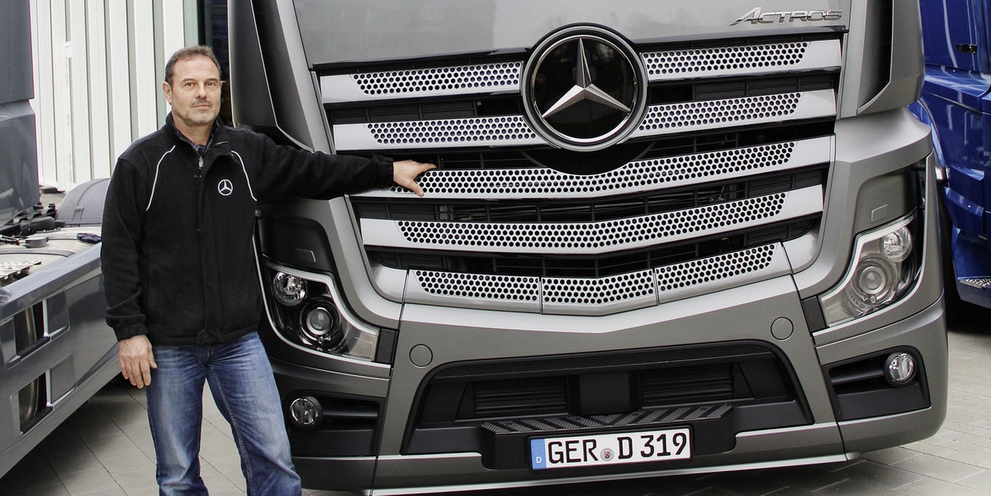 Man stands next to Daimler truck Man stands next to Daimler truck