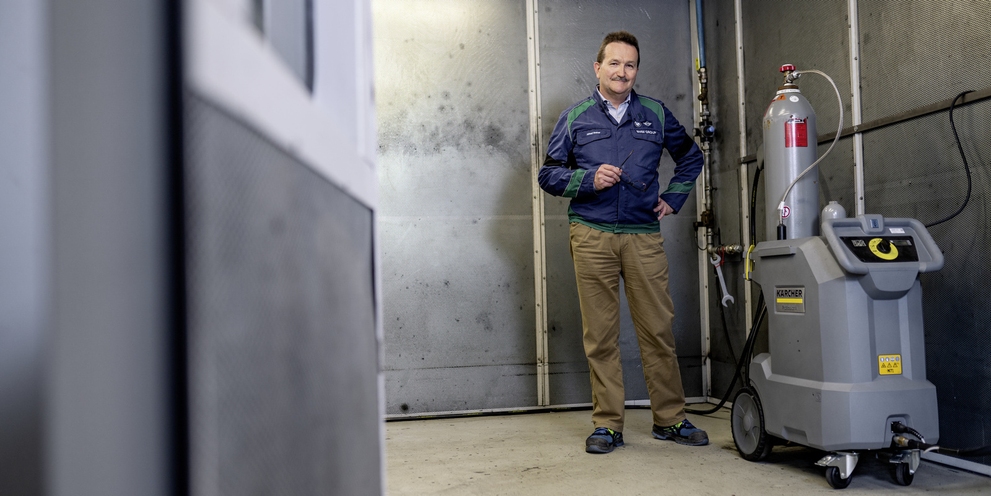 Man stands next to Kärcher machine Man stands next to Kärcher machine
