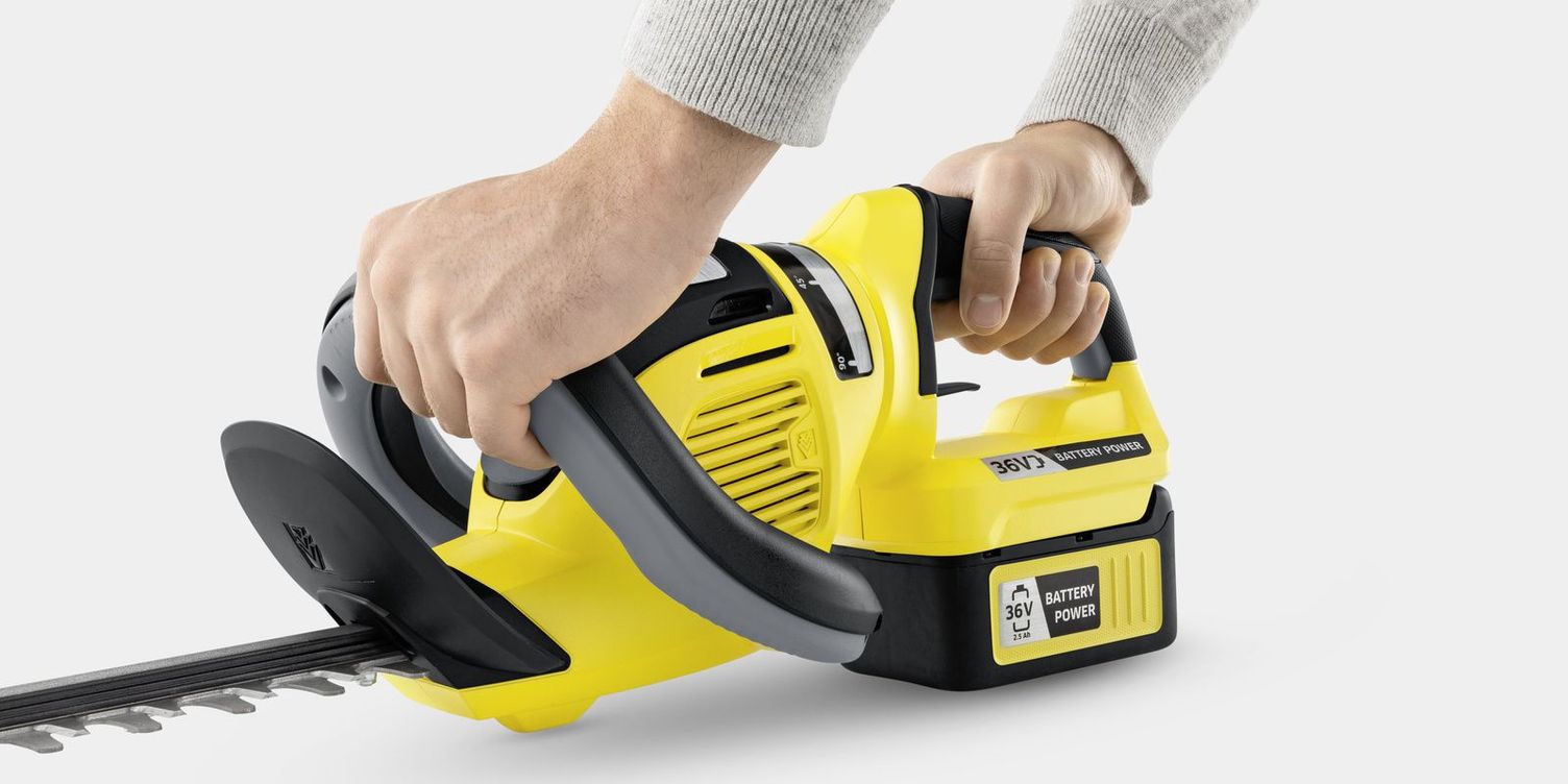 2 hands hold a Kärcher battery hedge trimmer
