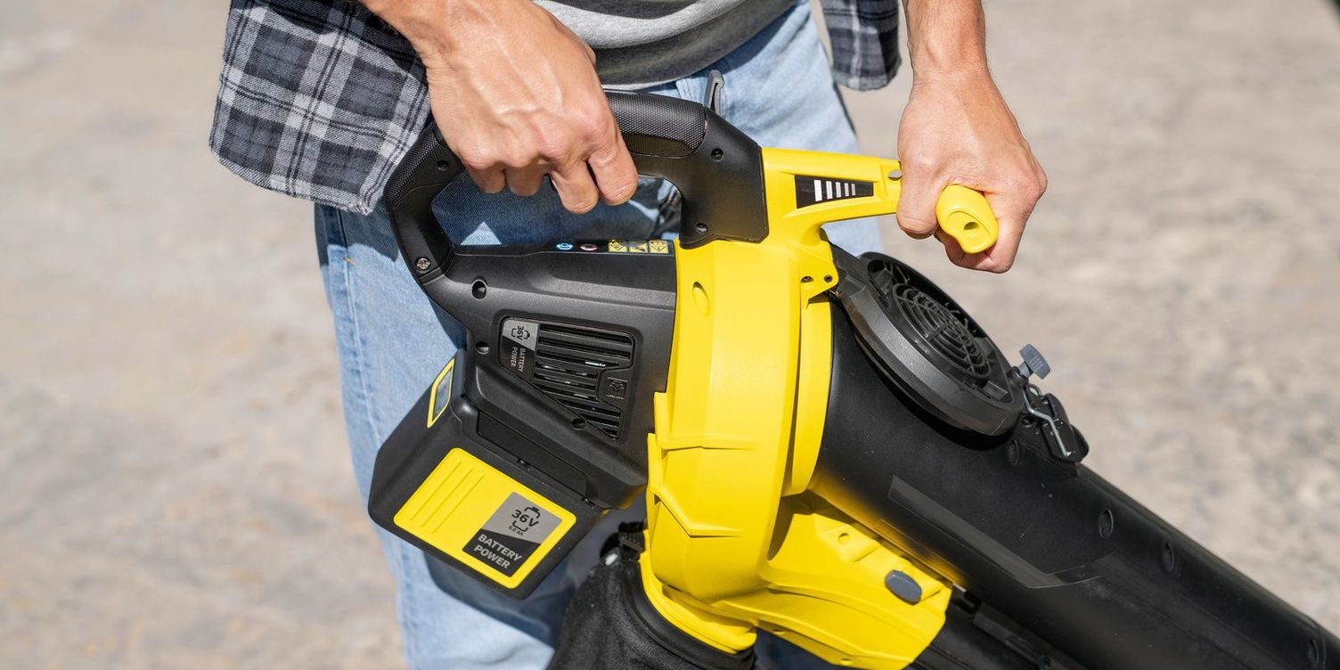 Two hands hold the Kärcher cordless leaf blower and garden vac