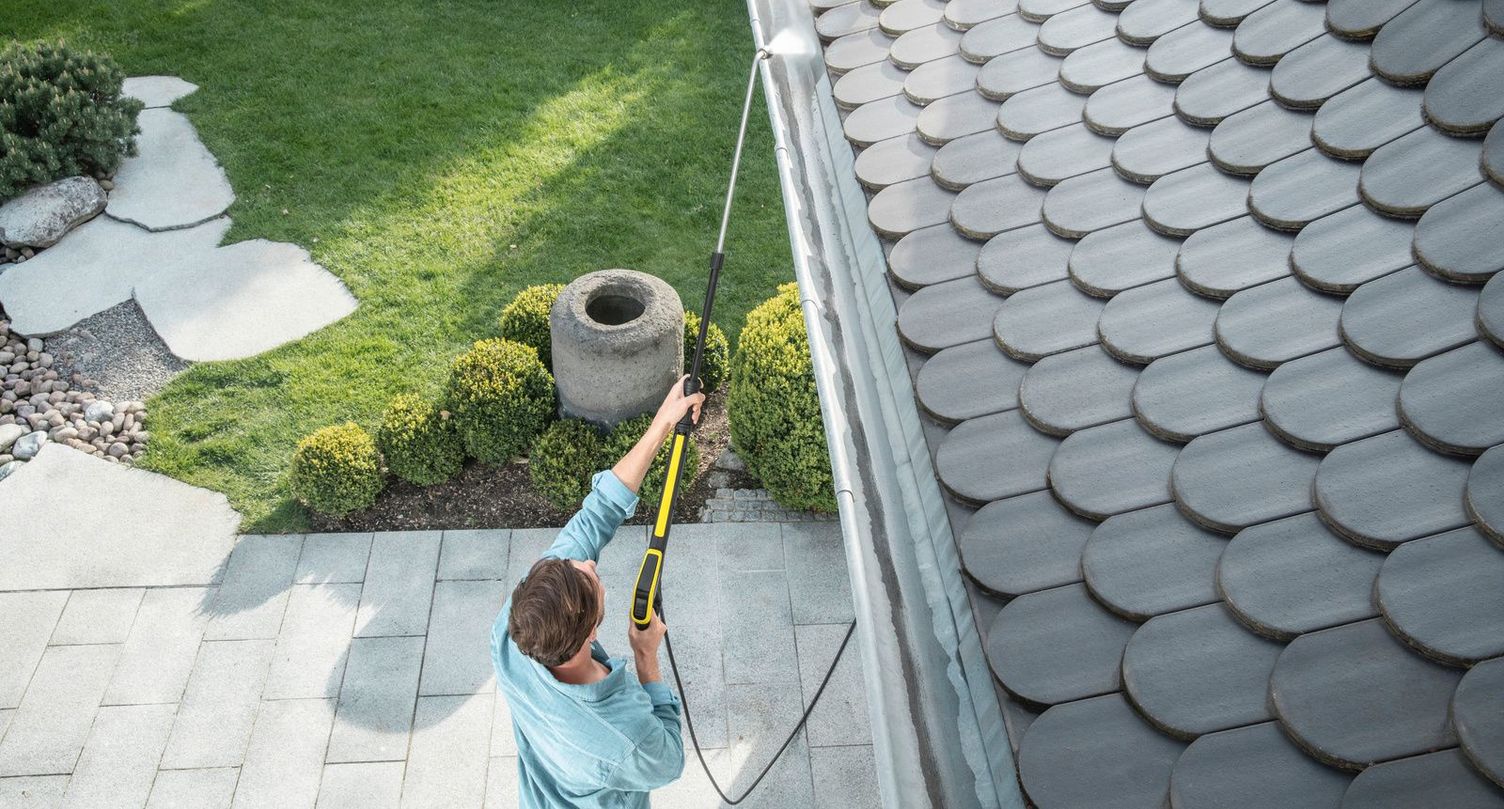 Man cleaning his gutter with a Kärcher pressure washer
