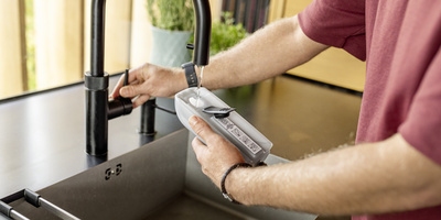 Person filling the water tank of a Kärcher floor cleaner