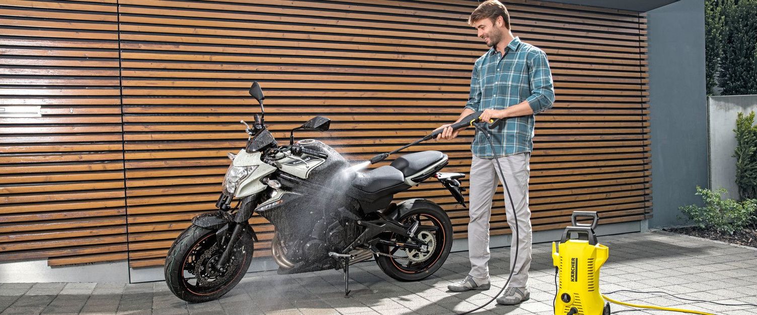 Motorcycle cleaning A man cleans his motorcycle with a Kärcher pressure washer