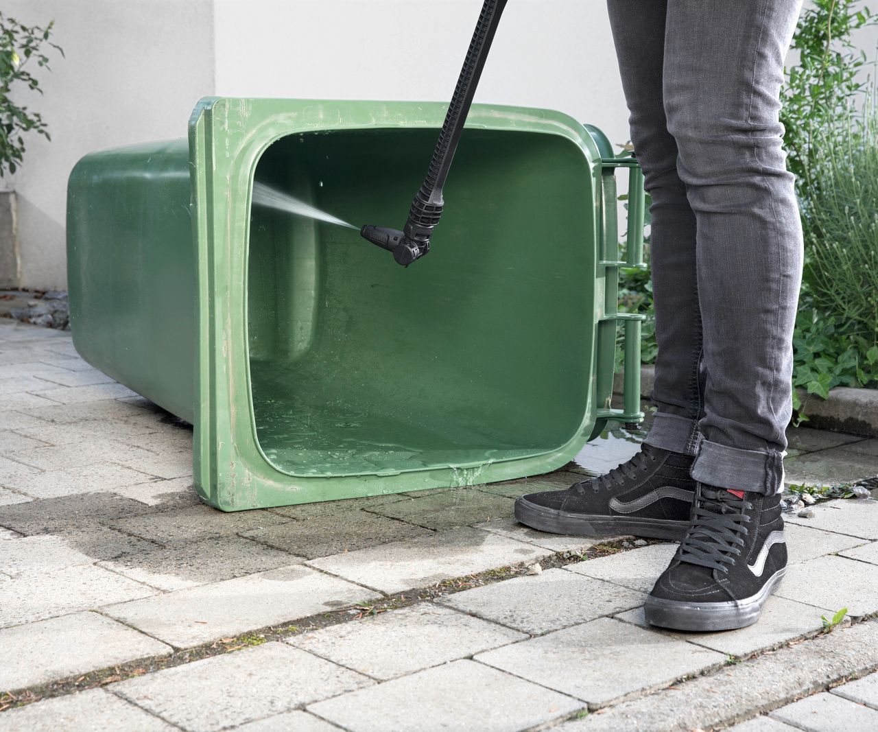 Use water pressure to wash out the dustbin A bin is washed out with a Kärcher medium pressure washer
