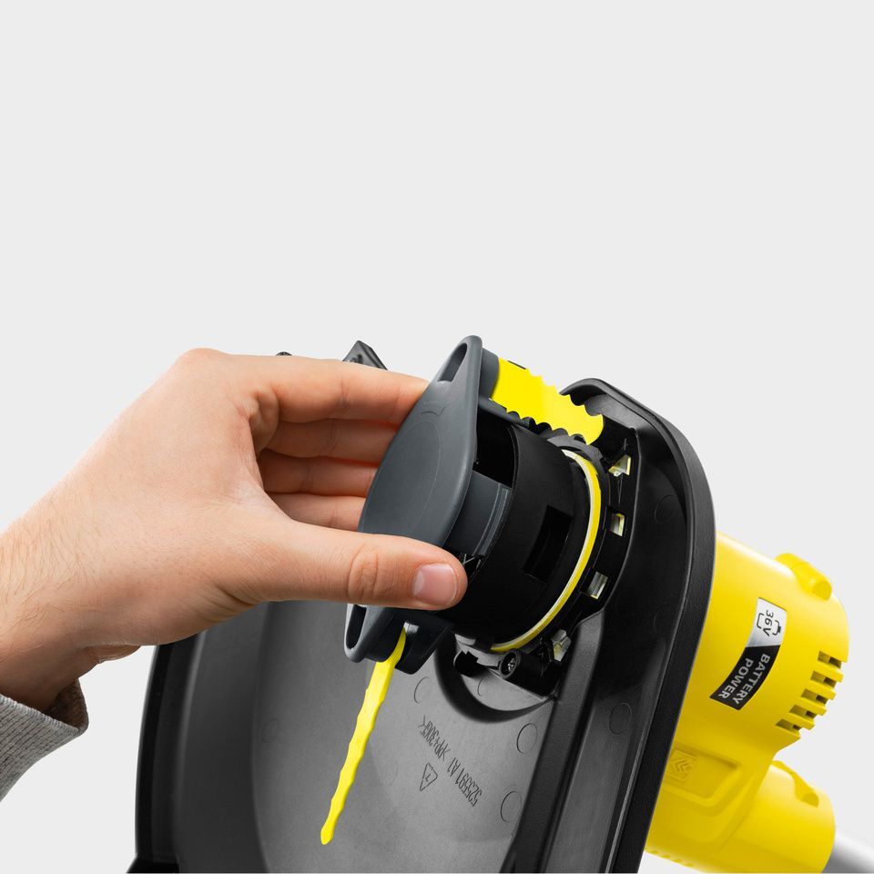 One hand installs trimmer blade on Kärcher battery lawn trimmer