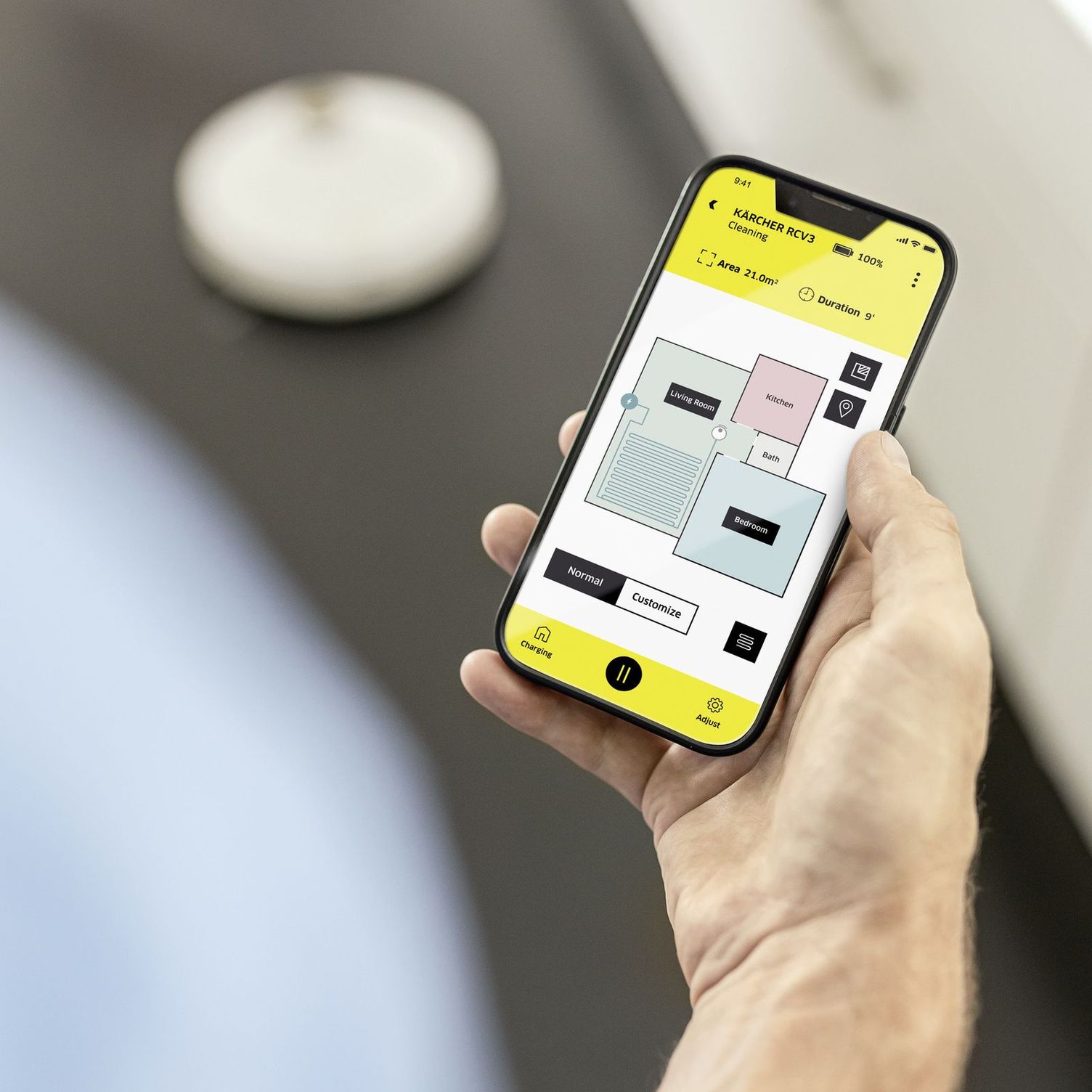 Person controlling robotic vacuum cleaner by smartphone app