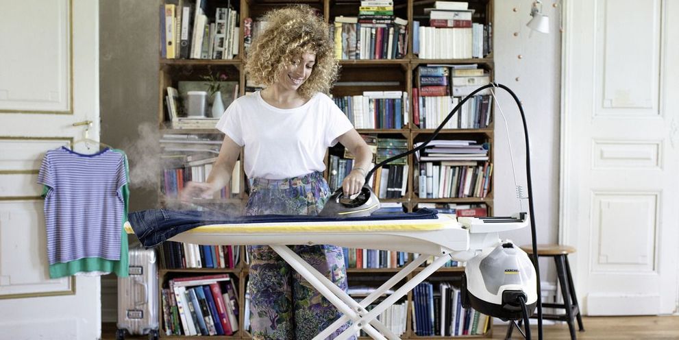 Woman ironing with steam cleaner with steam pressure iron