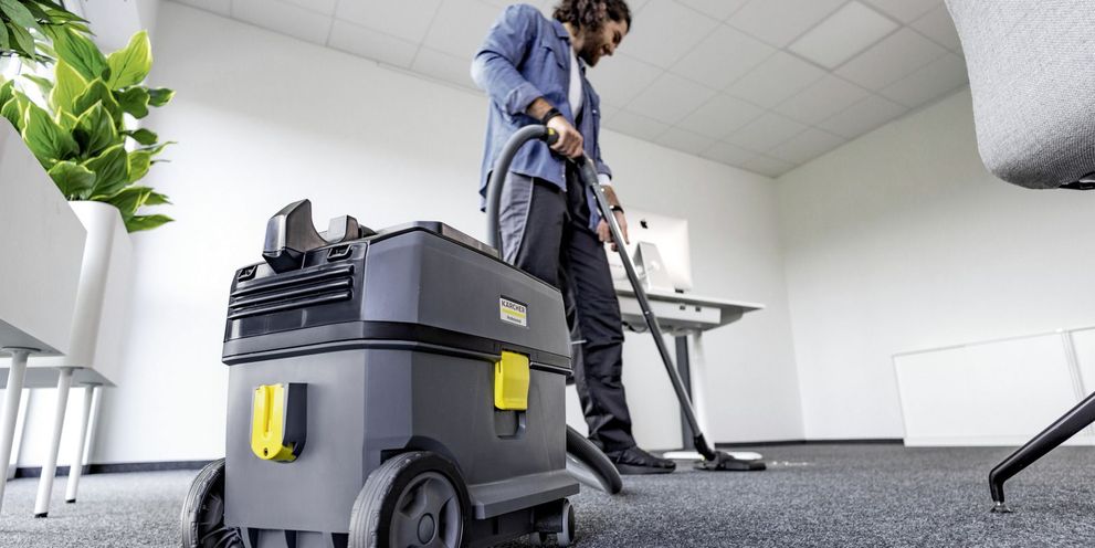 Vacuuming an office with a Kärcher battery-powered dry vacuum cleaner