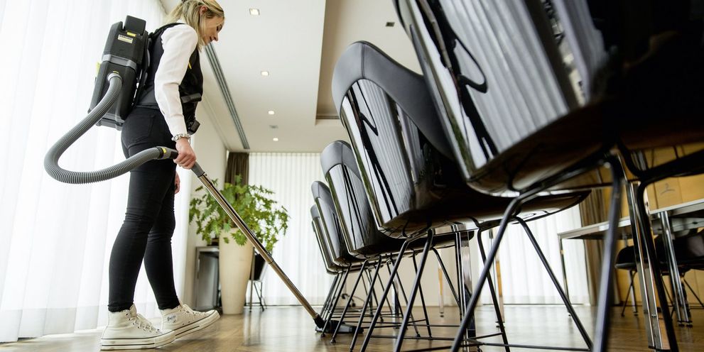 A Kärcher battery-powered dry vacuum cleaner cleaning a conference room
