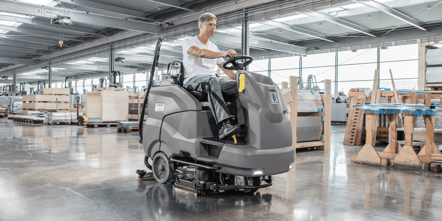 Scrubbers For Efficient Cleaning Man uses a ride-on floor scrubber to clean production floors