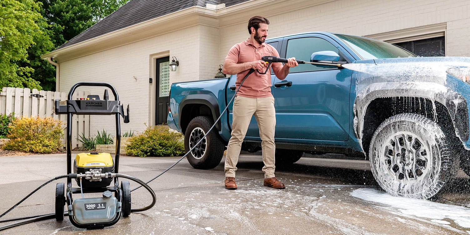 A man uses Kärcher battery-powered vacuum cleaner VC 4 to clean his couch.