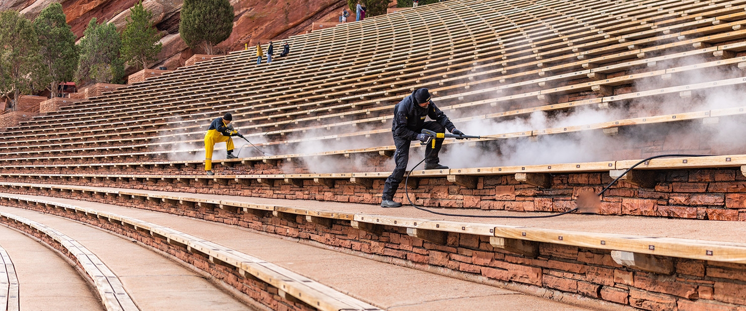 A worker uses a Kärcher hot water pressure washer to clean under benches at the Red Rocks Amphitheatre outside Denver