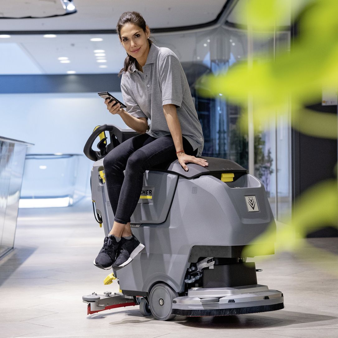 Same High Quality, Next-Generation Technology Woman sits on a B 50 W Bp walk-behind floor scrubber.