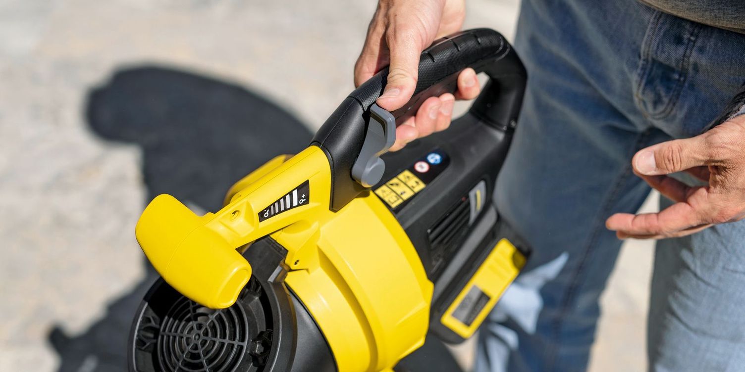 Hands hold the Kärcher cordless leaf blower and garden vac