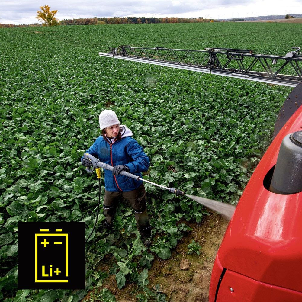 Cordless Pressure Washing A worker cleans agriculture equipment in the field with a cordless CleanWave pressure washer.