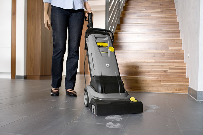 Different types of damage and cleaning techniques A worker cleans flooring with a floor scrubber