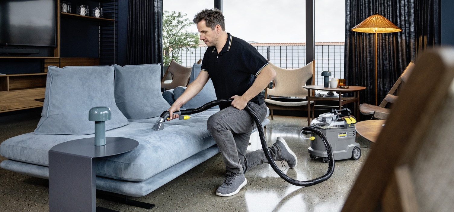 Success Starts With Planning A person cleaning the sofa with a Kärcher spray extraction device.