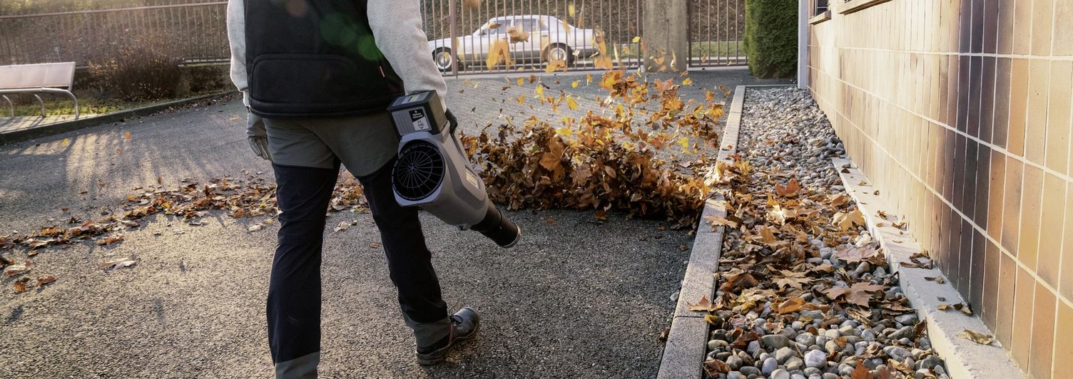 A person operating a leaf blower