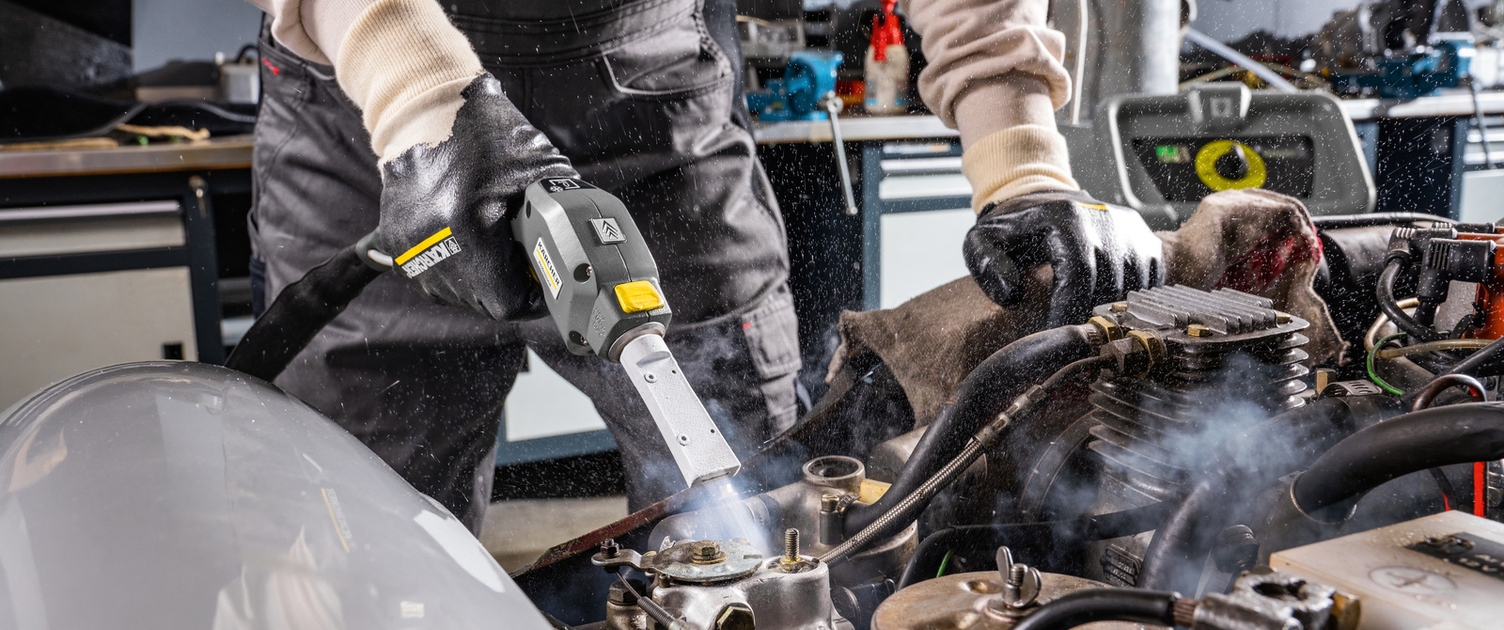 A New Dimension of Cleaning A worker uses a dry ice blaster to clean under the hood of a car.