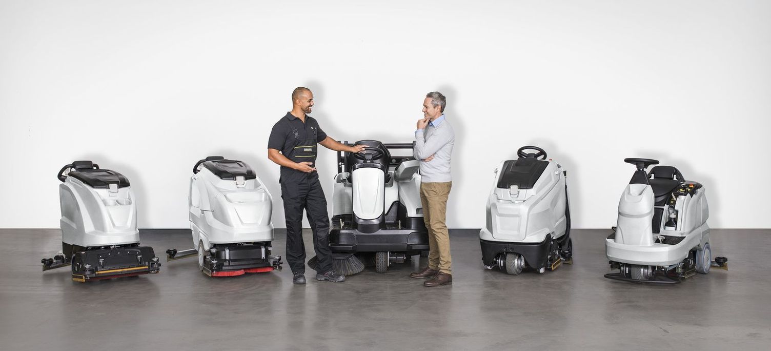 Service From a Single Source Two men talk while standing beside five floor care machines.