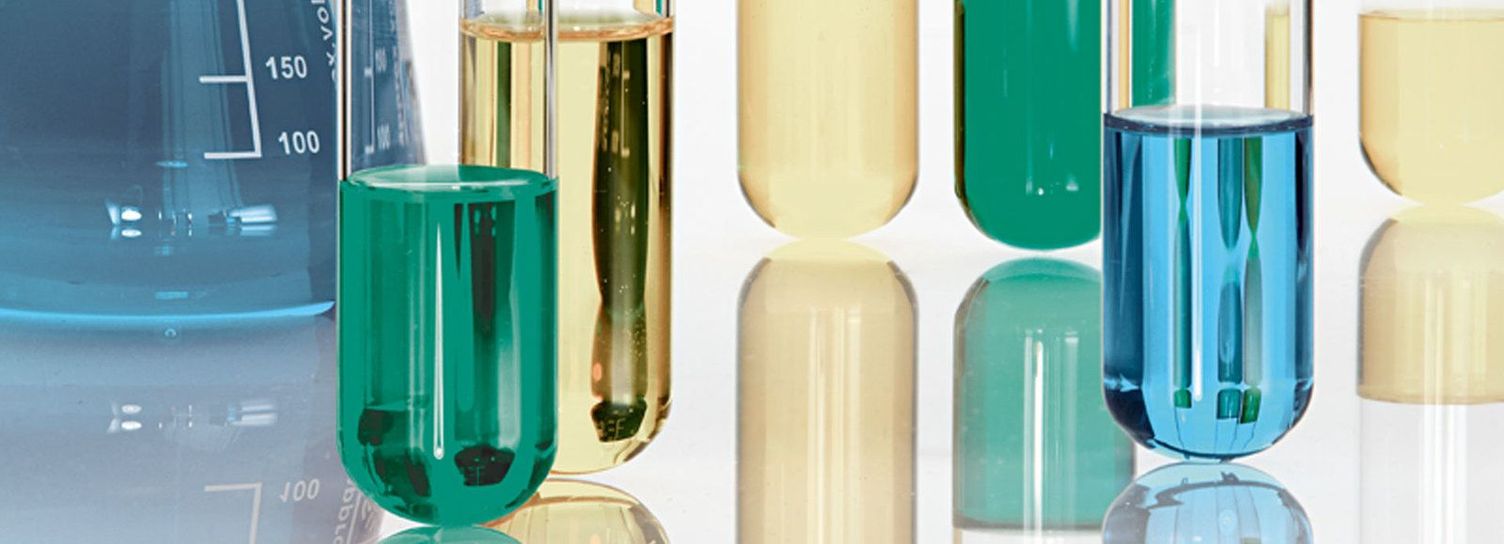 A series of beakers, graduated cylinders, and other scientific testing glassware.