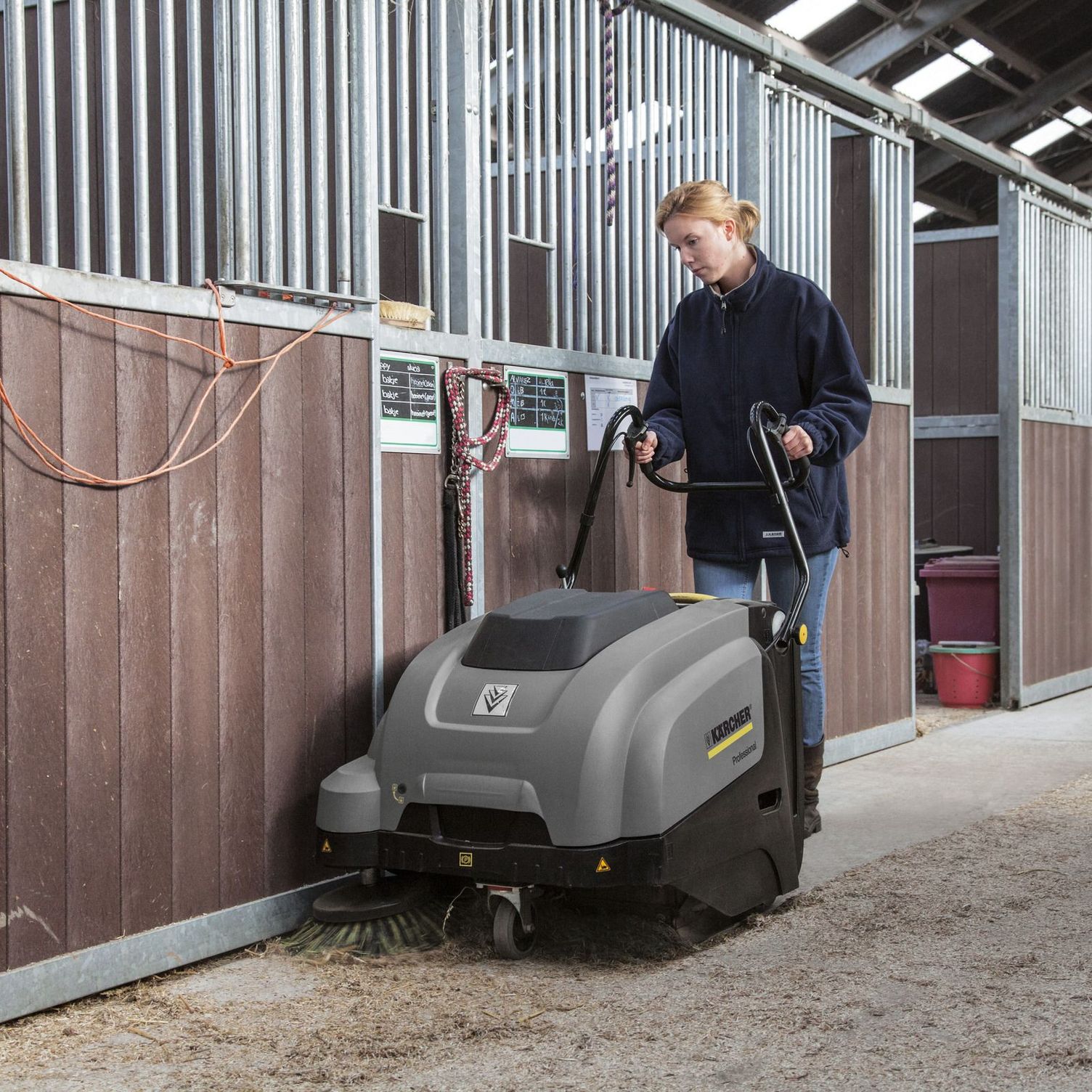 Simple Operation, Simple Maintenance A worker uses a Kärcher KM 75/40 W to clean in a barn.